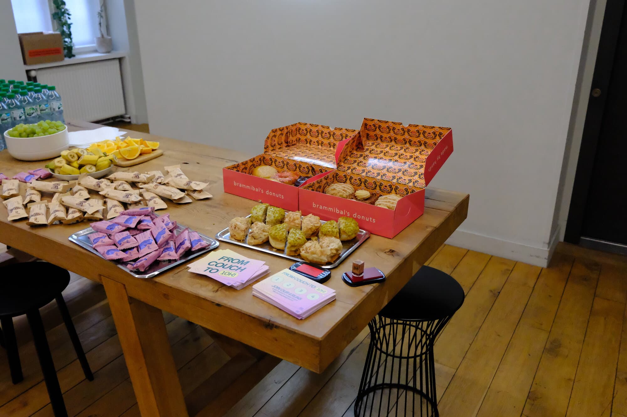 A table with snacks, fruit, and drinks set up for an event.