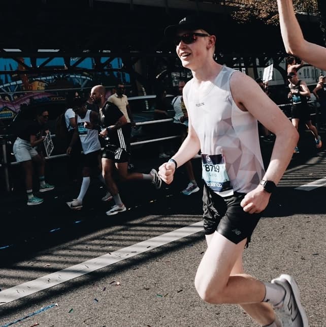 A runner participates in a marathon event, smiling under sunny conditions.